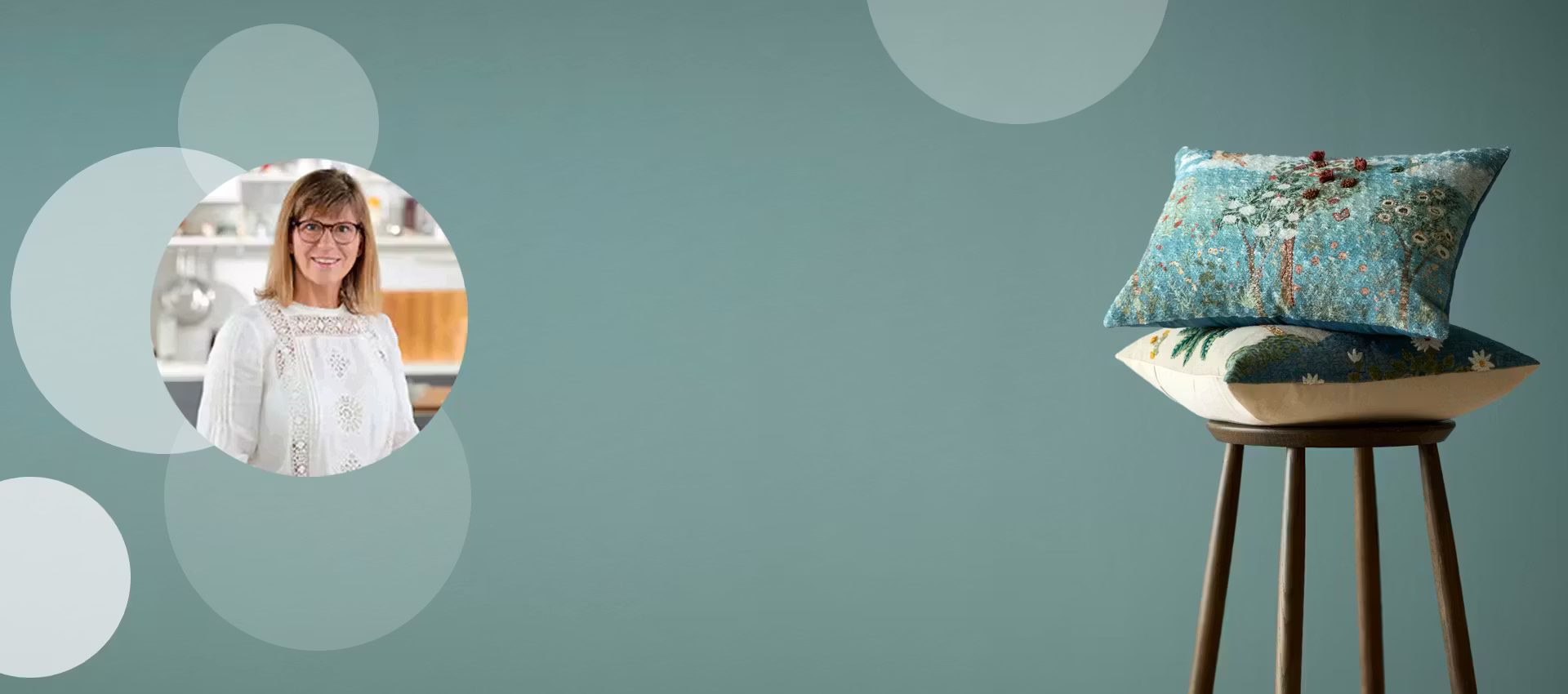 Dekorativ bakgrundsbild med ljusa cirklar på grön vägg där en stol med ett par prydnadskuddar står i högra hörnet.