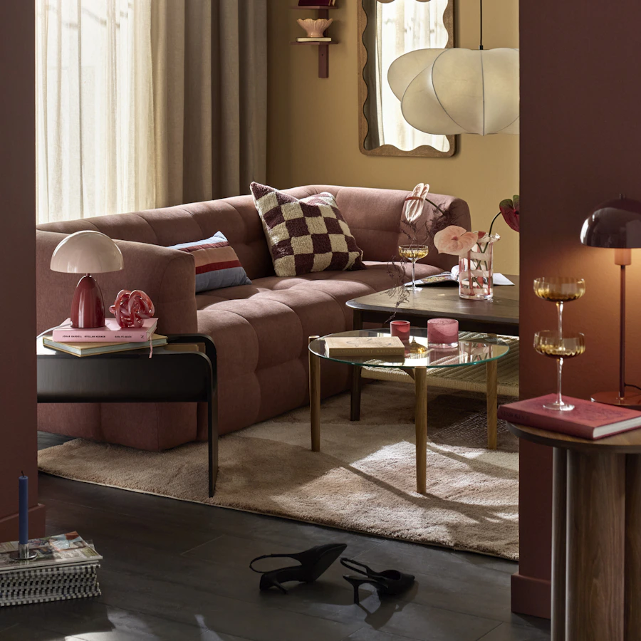 Vardagsrum med en trendig bubblig soffa i mörkröd och gula nyanser på färgerna.