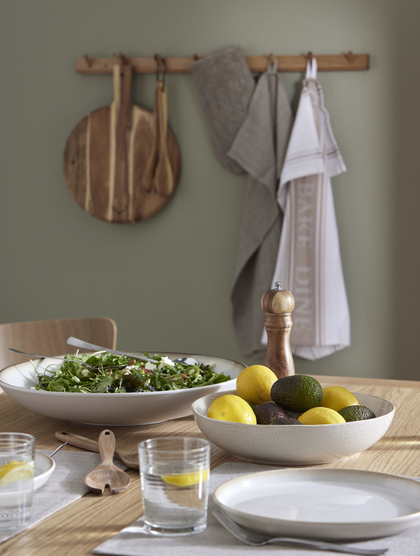 vitt porslin i form av skålar och tallrikar står uppdukade på ett matbord