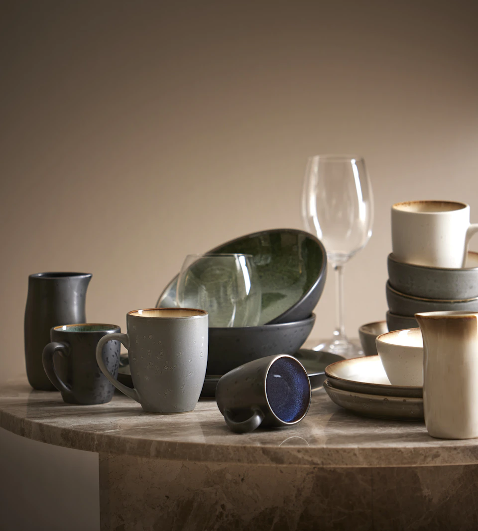 porslin i form av skålar och tallrikar står uppdukade på ett matbord