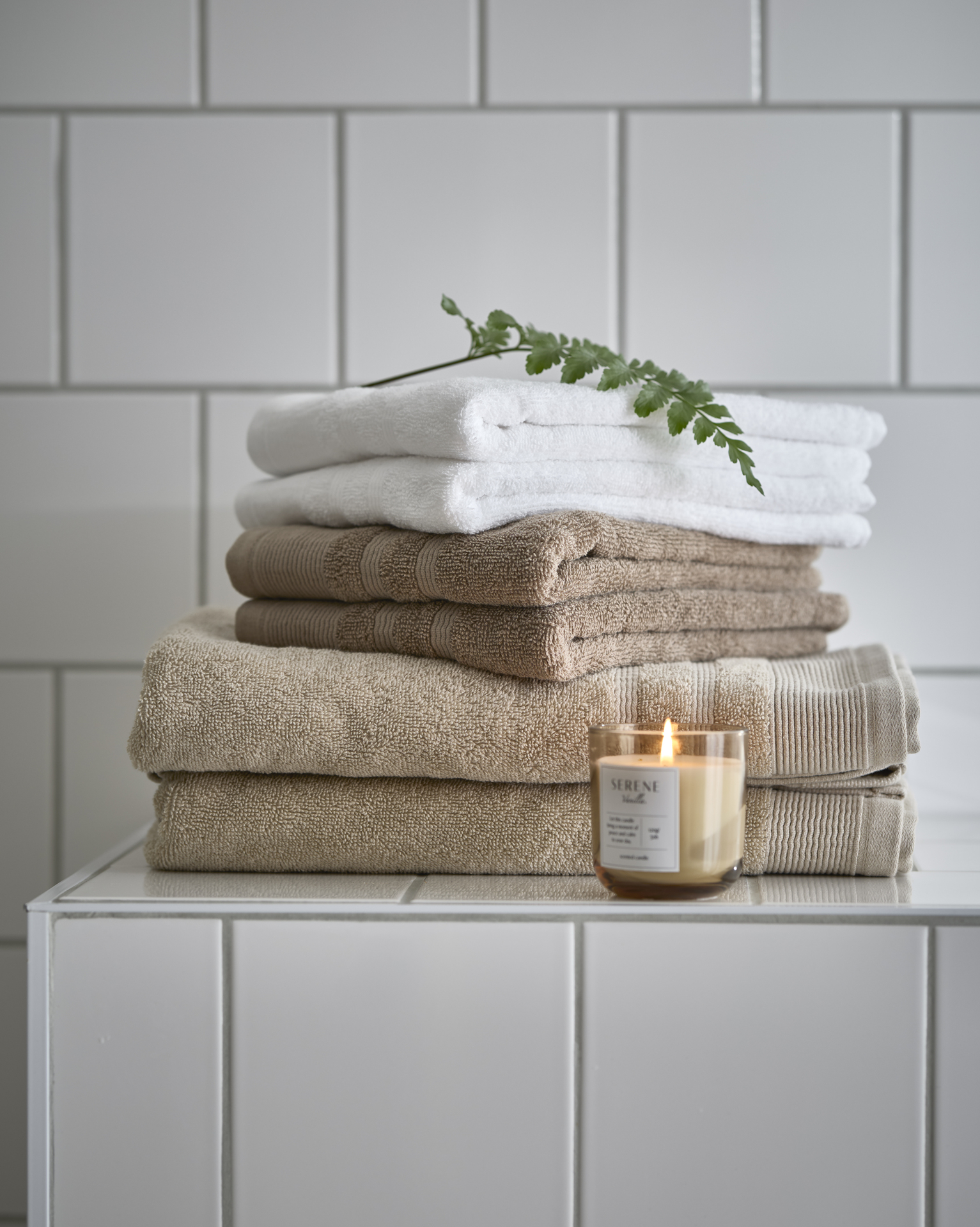 en hög med ihopvikta handdukar i vitt och beige