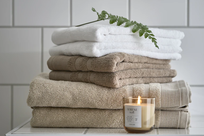en hög med ihopvikta handdukar i vitt och beige