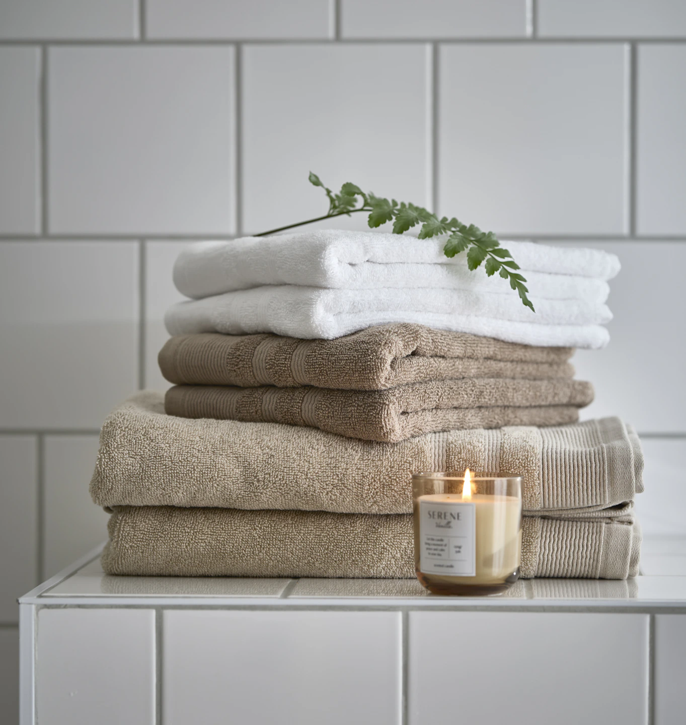 en hög med ihopvikta handdukar i vitt och beige