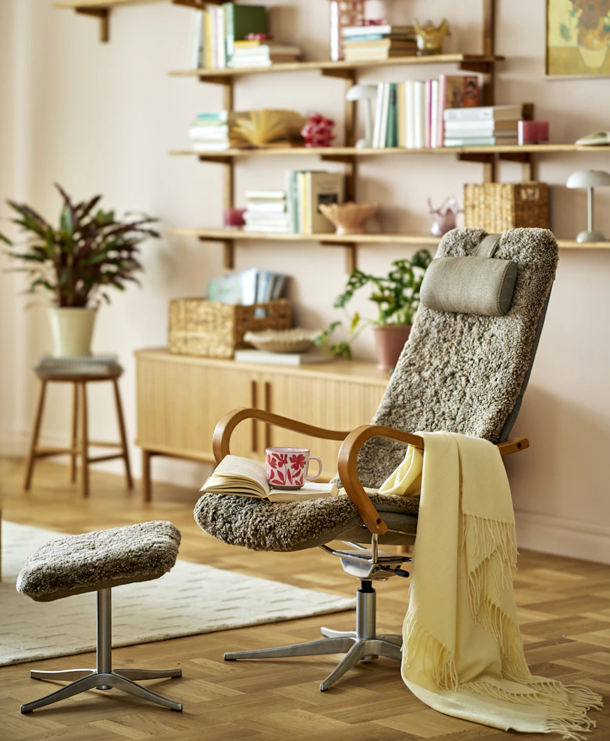 en brun fårskinnsfåtölj står i ett vardagsrum med många ljusa detaljer