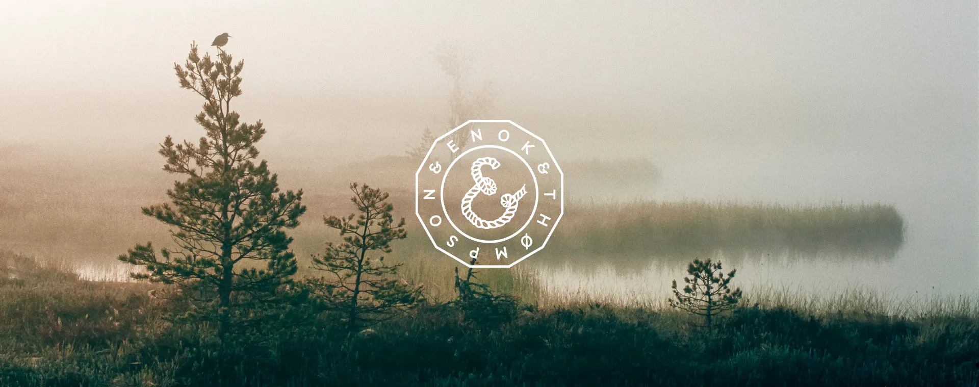 en vit logotyp ligger mot en bild på natur