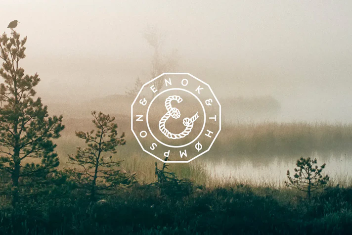 en vit logotyp ligger mot en bild på natur