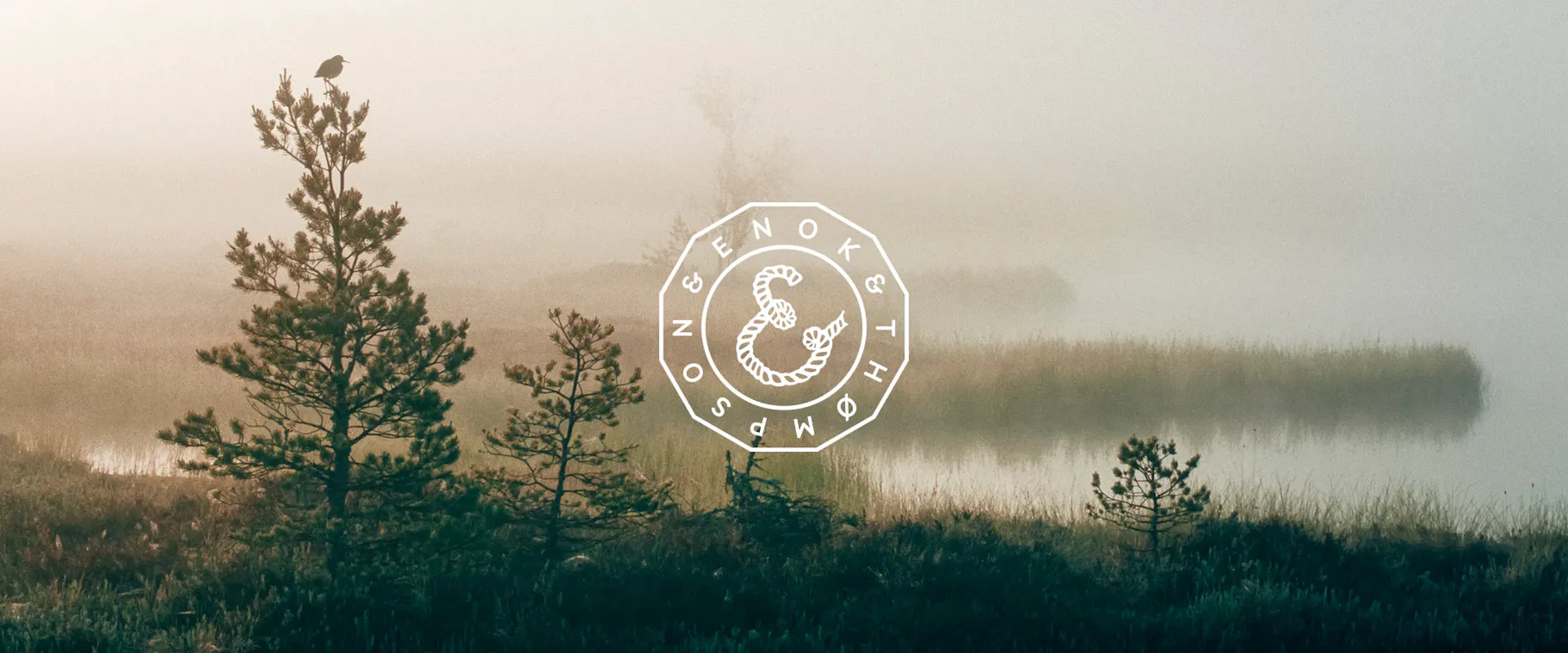 en vit logotyp ligger mot en bild på natur