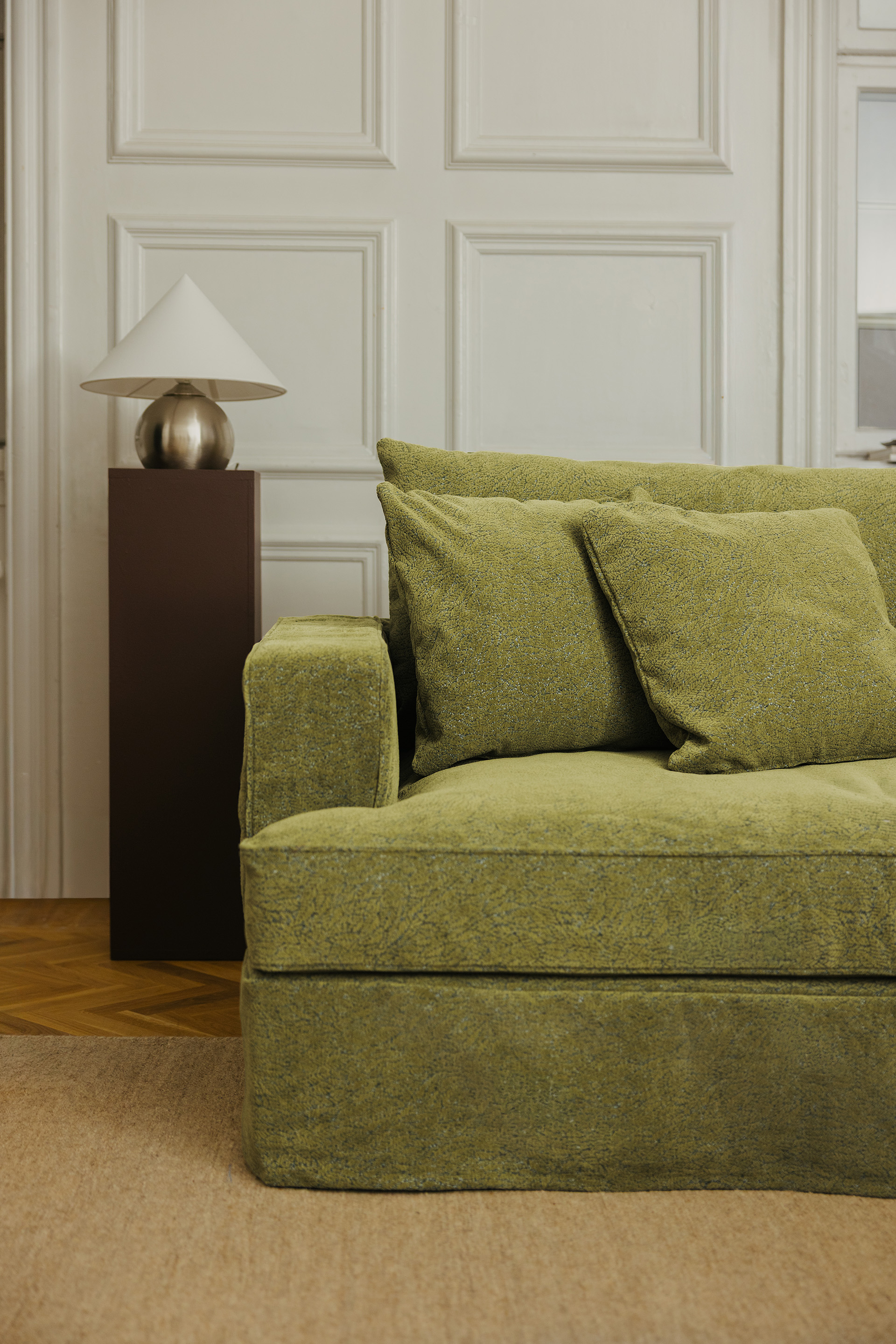 Halv soffa med kraftigt armstöd och mossgrönt tyg