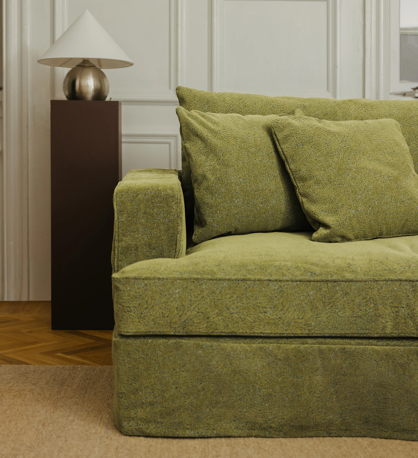 Halv soffa med kraftigt armstöd och mossgrönt tyg