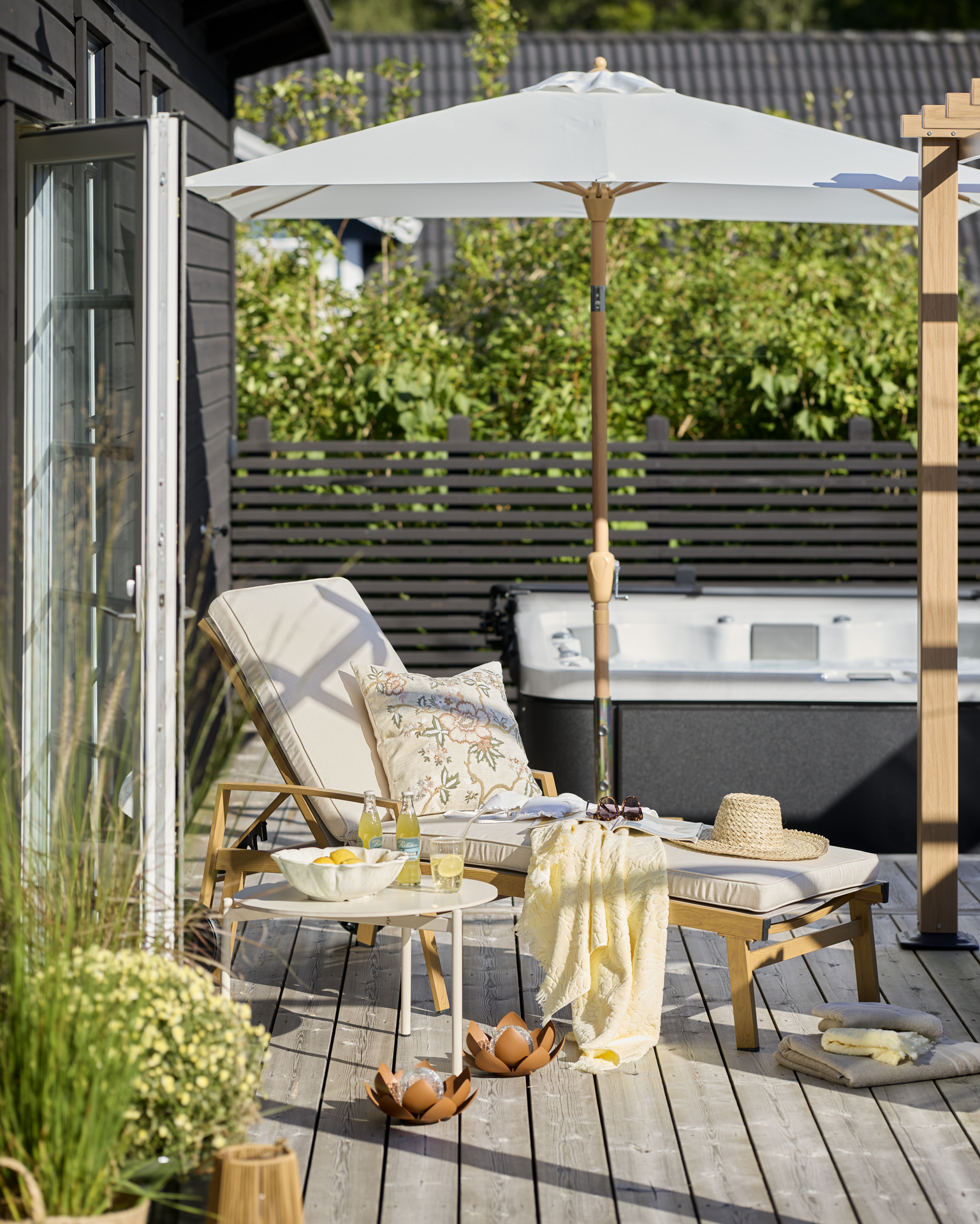 en solstol står på en altan framför en bubbelpool