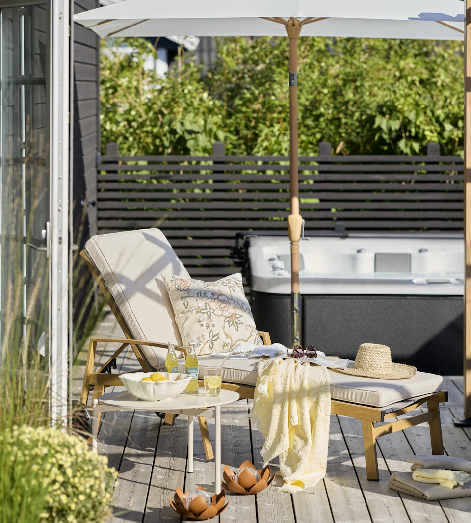 en solstol står på en altan framför en bubbelpool