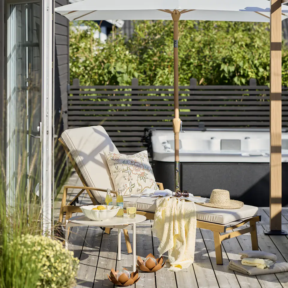 en solstol står på en altan framför en bubbelpool