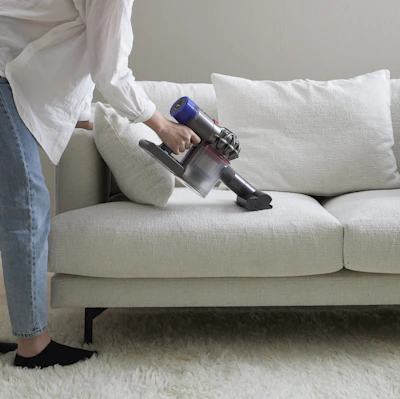 en person dammsuger en vit soffa