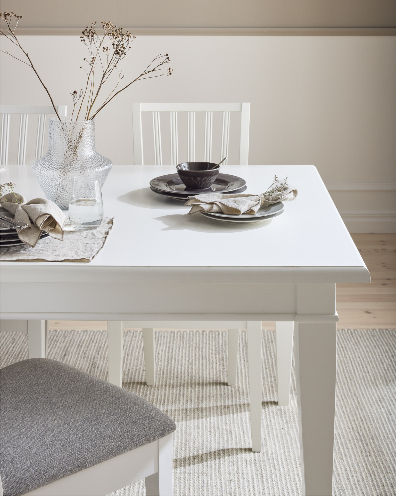 Ett vitt matbord är dukat med porslin i brunt.