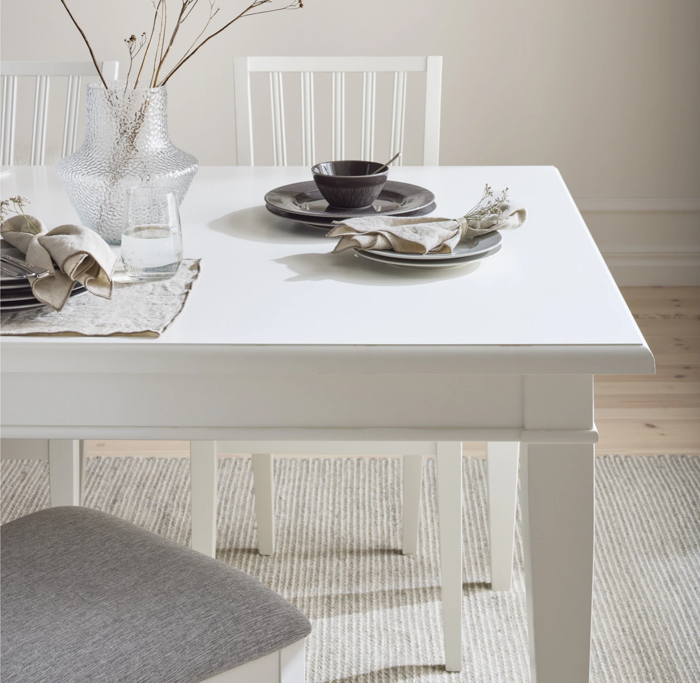 Ett vitt matbord är dukat med porslin i brunt.