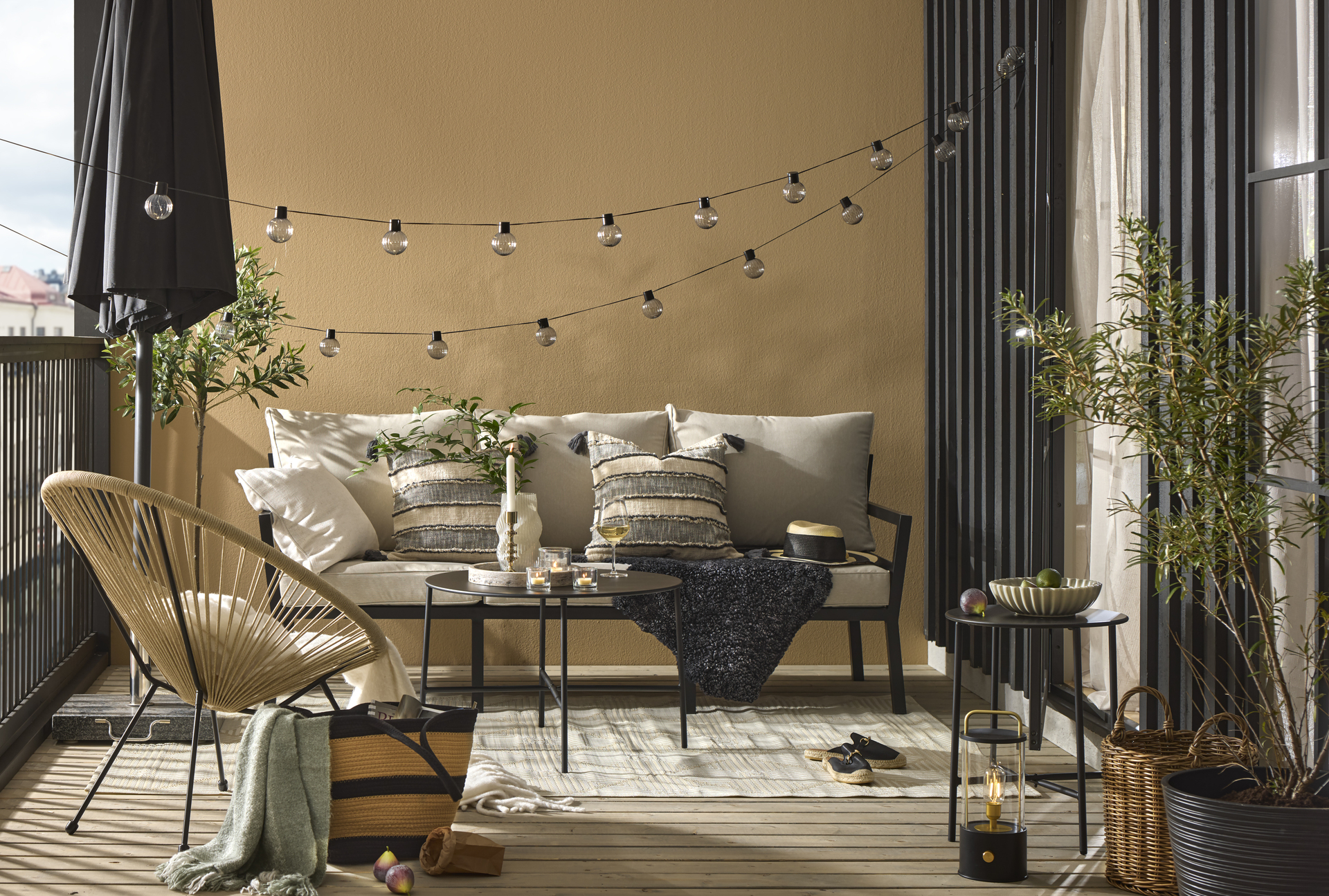 en utesoffa står på en uteplats med ett soffbord, fåtölj och matta