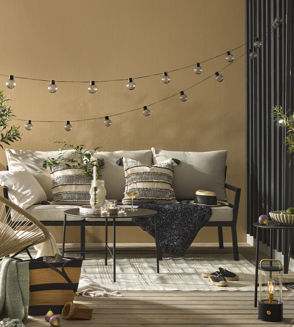 en utesoffa står på en uteplats med ett soffbord, fåtölj och matta