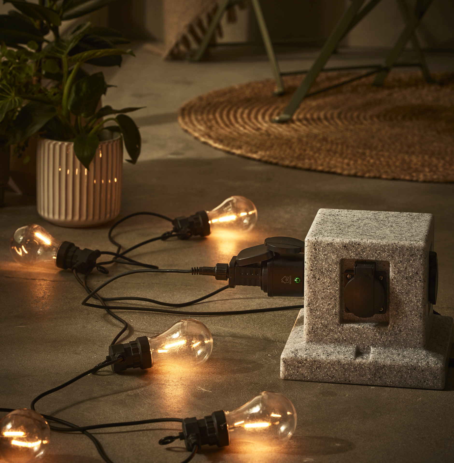 en ljusslinga med stora lampor ligger på ett stengolv