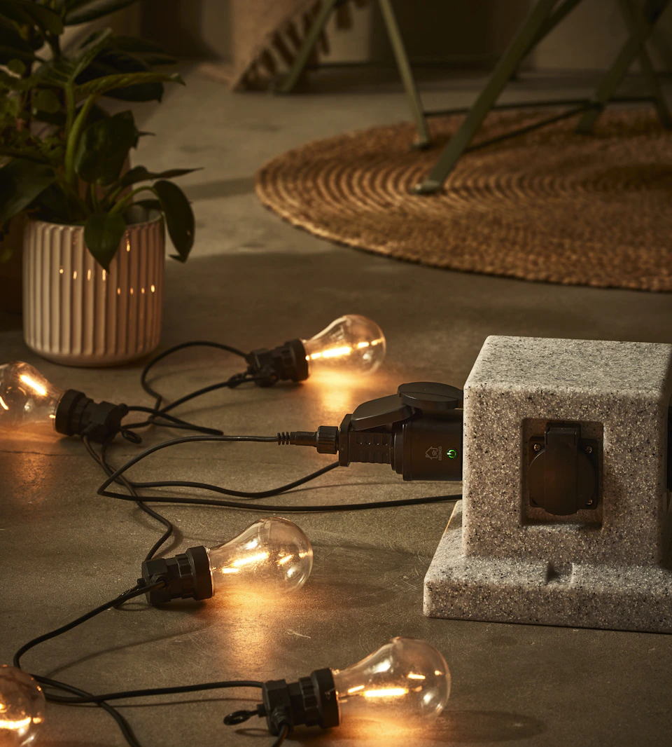 en ljusslinga med stora lampor ligger på ett stengolv