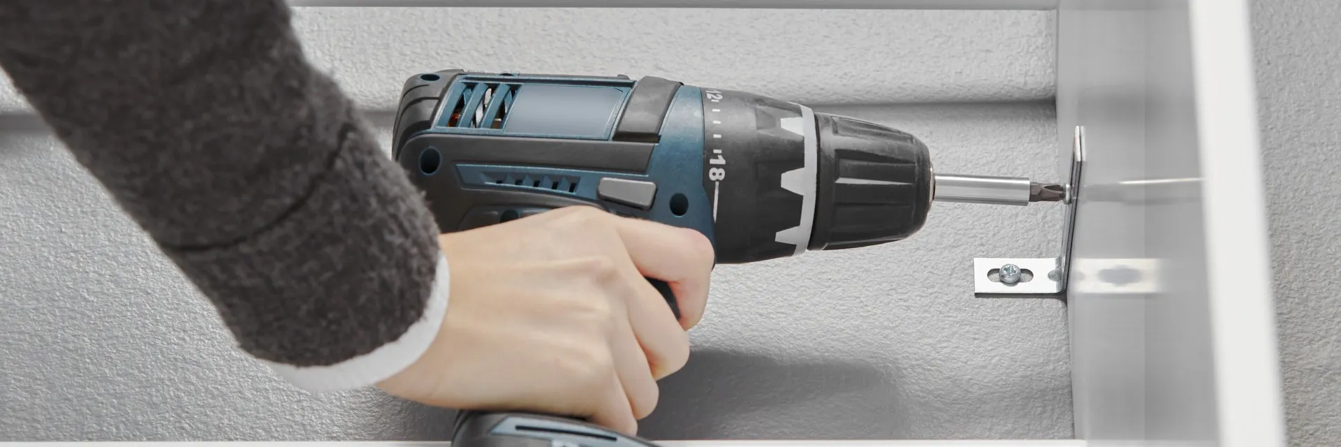 en hand håller i en skruvdragare 