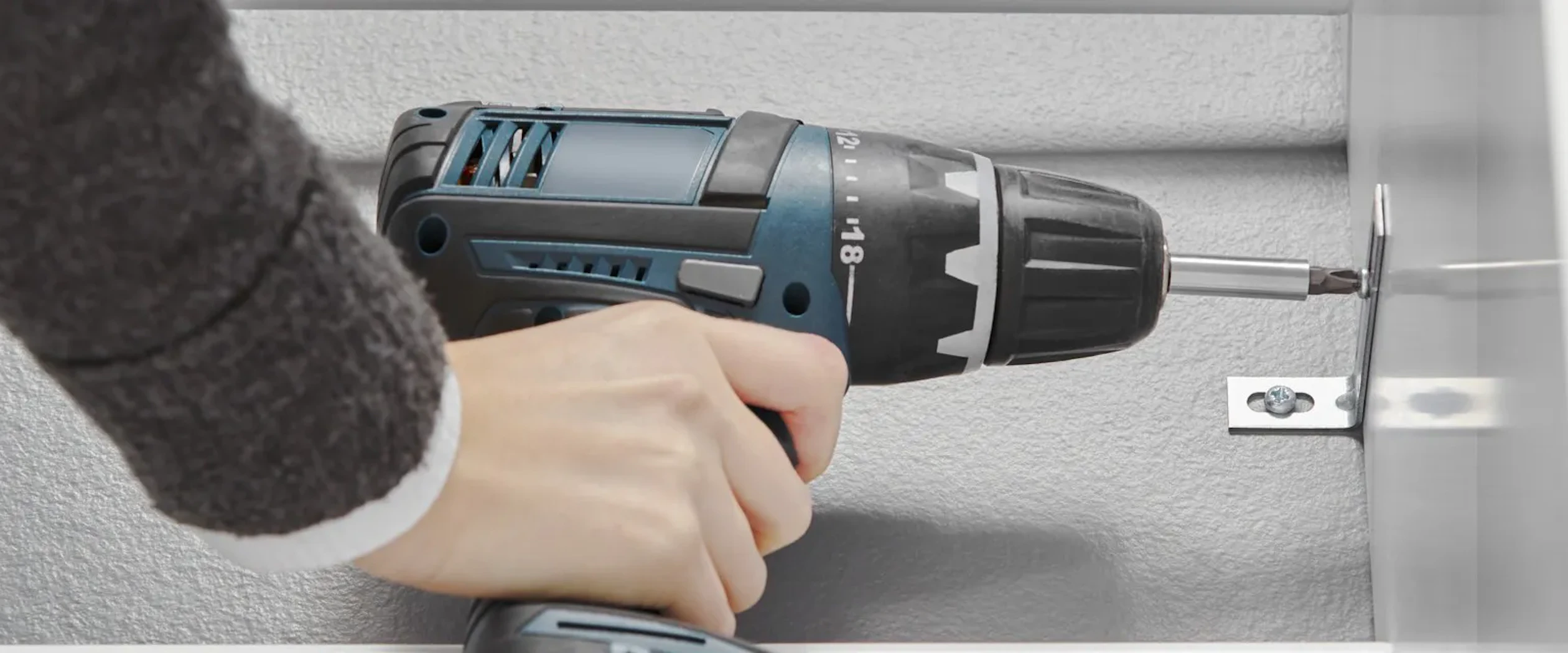 en hand håller i en skruvdragare