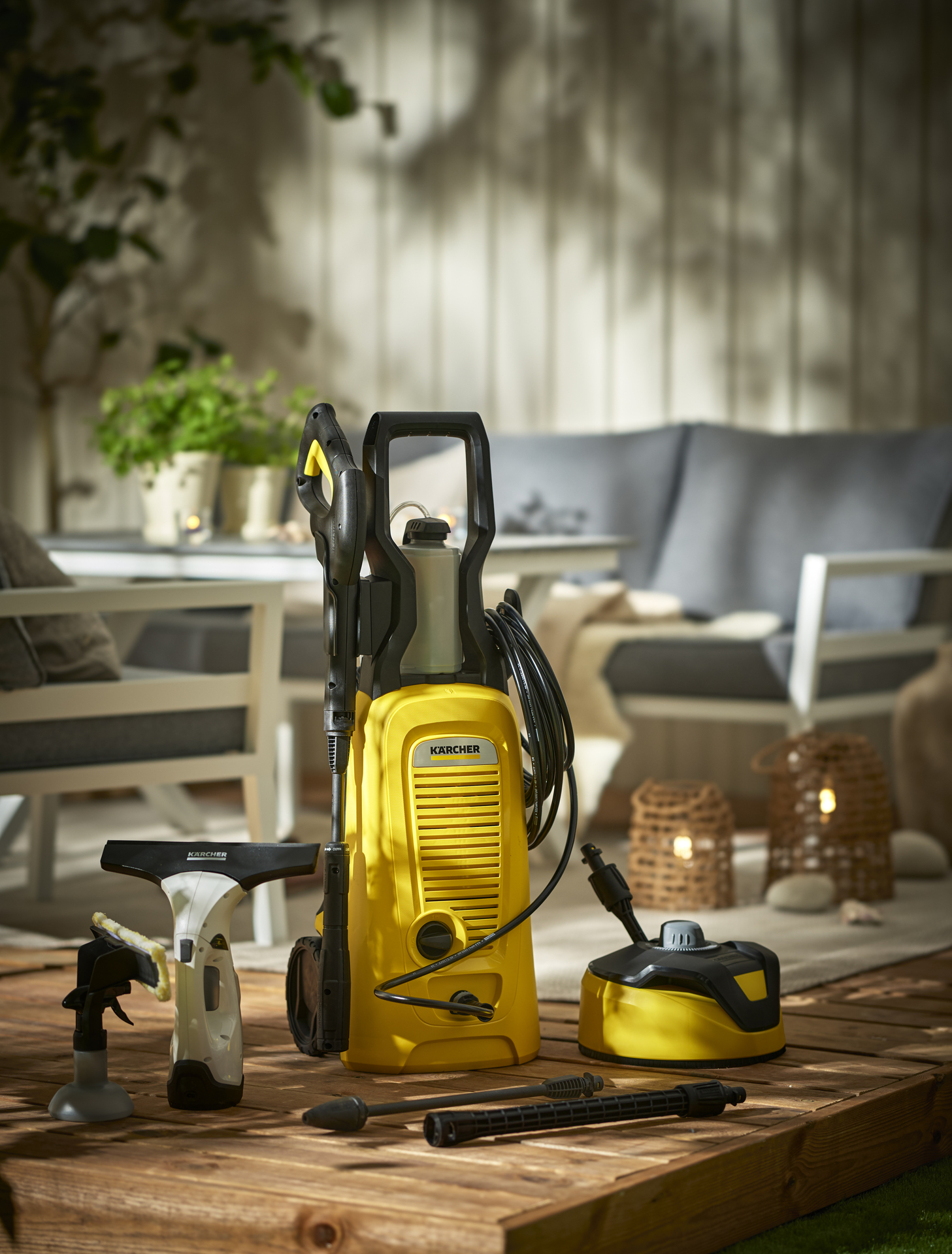 Produkter för rengöring från Kärcher står uppställda på ett trallgolv i en uteplatsmiljö 