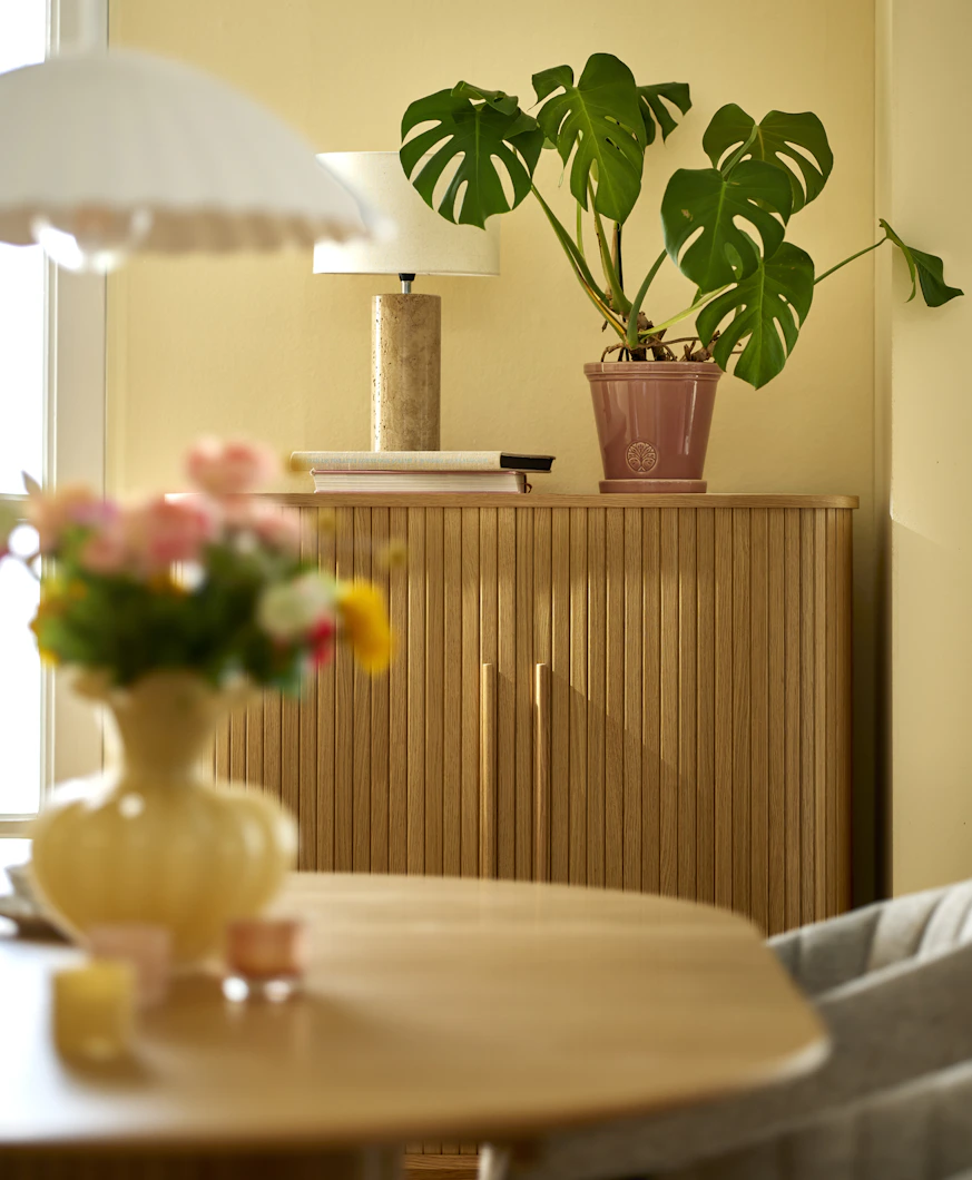 ett ribbat skåp står mot en gul vägg