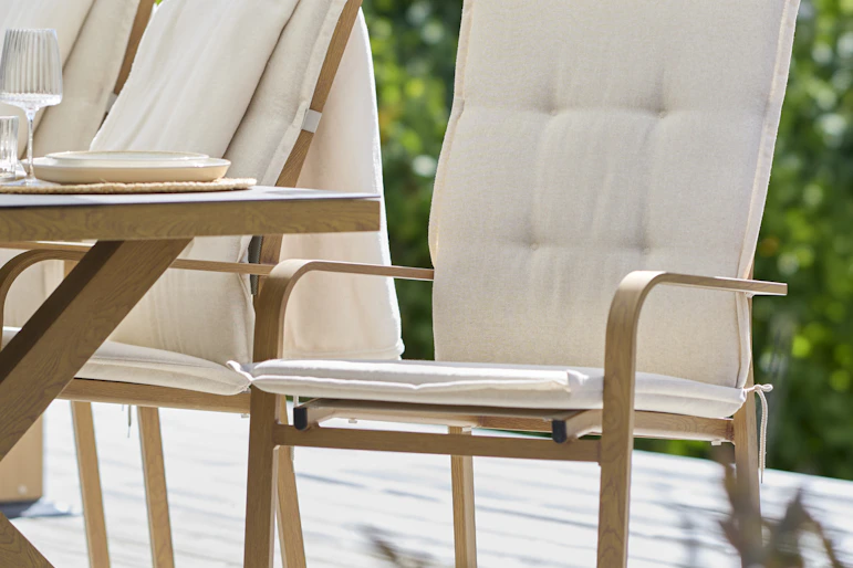 en utestol med en vit dyna står på en altan utomhus