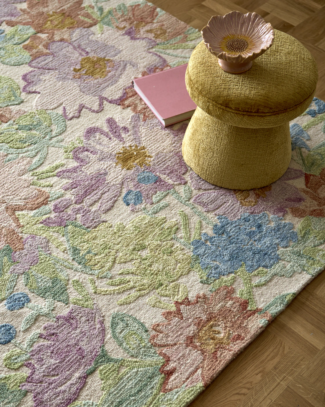 Matta i färgglatt, blommigt mönster med en gul puff på i bakgrunden