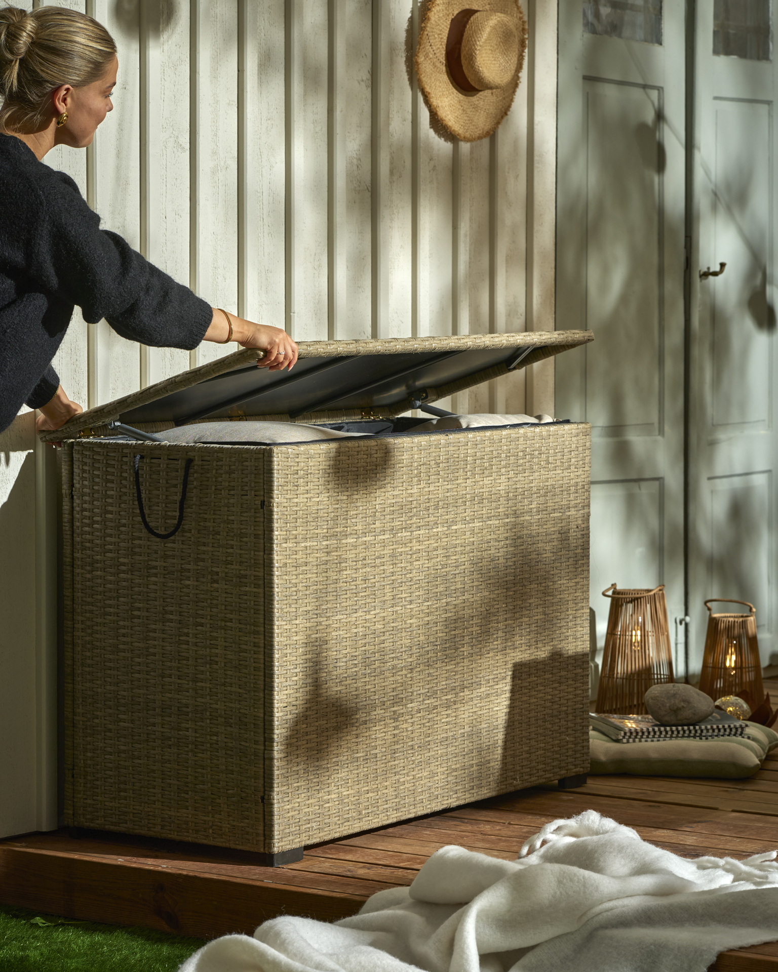 En person öppnar en sandfärgad dynbox som är full av kuddar.