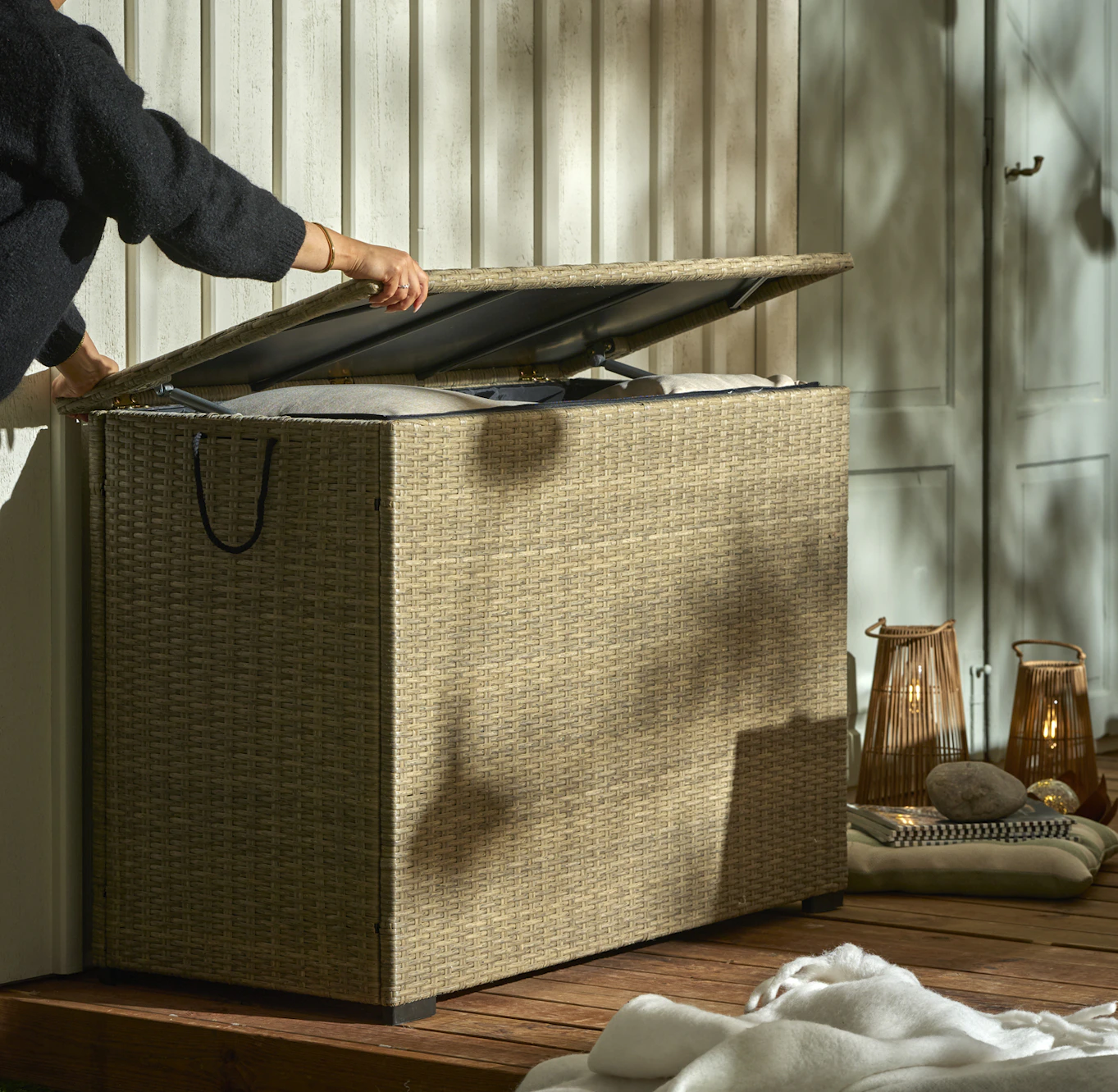 En person öppnar en sandfärgad dynbox som är full av kuddar.