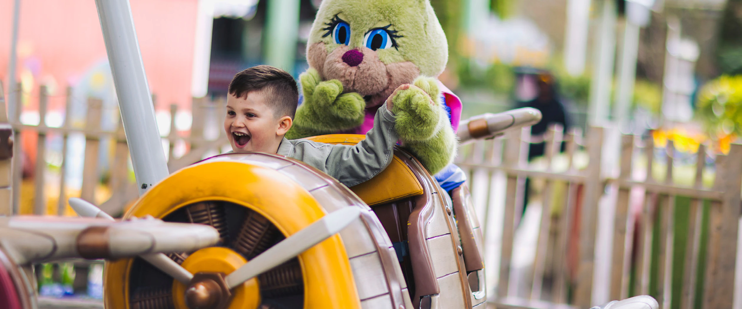 I en åkattraktion sitter ett barn med en Lisebergskanin bakom