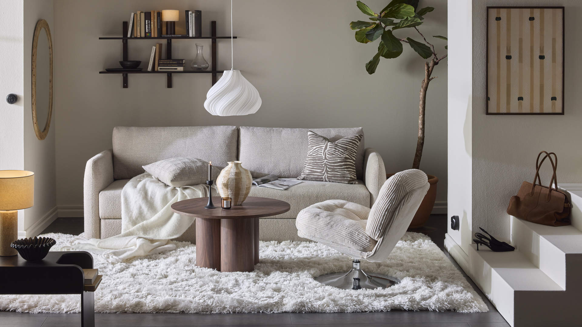 En beige bäddsoffa med raka linjer står i ett vardagsrum inrett i neutrala toner