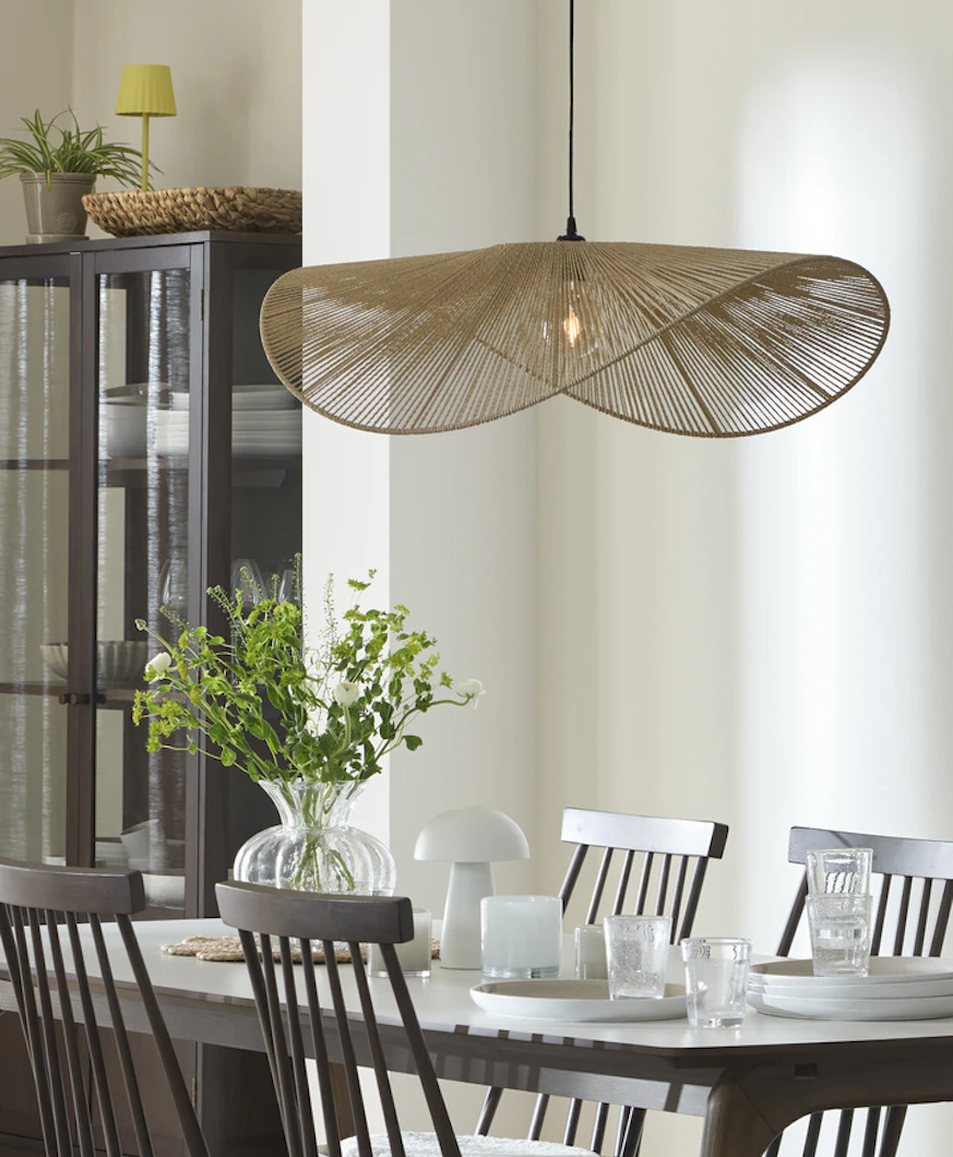 En stor lampa i organisk for hänger över ett matbord