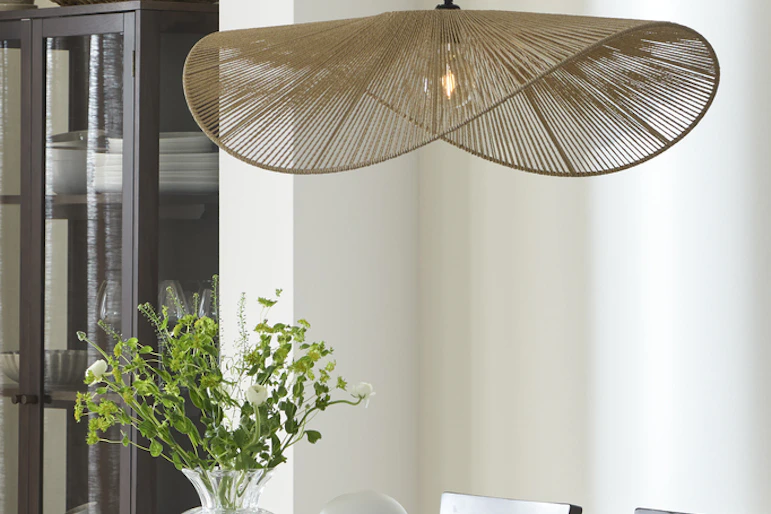 En stor lampa i organisk for hänger över ett matbord
