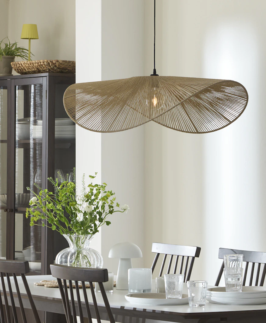 En stor lampa i organisk for hänger över ett matbord