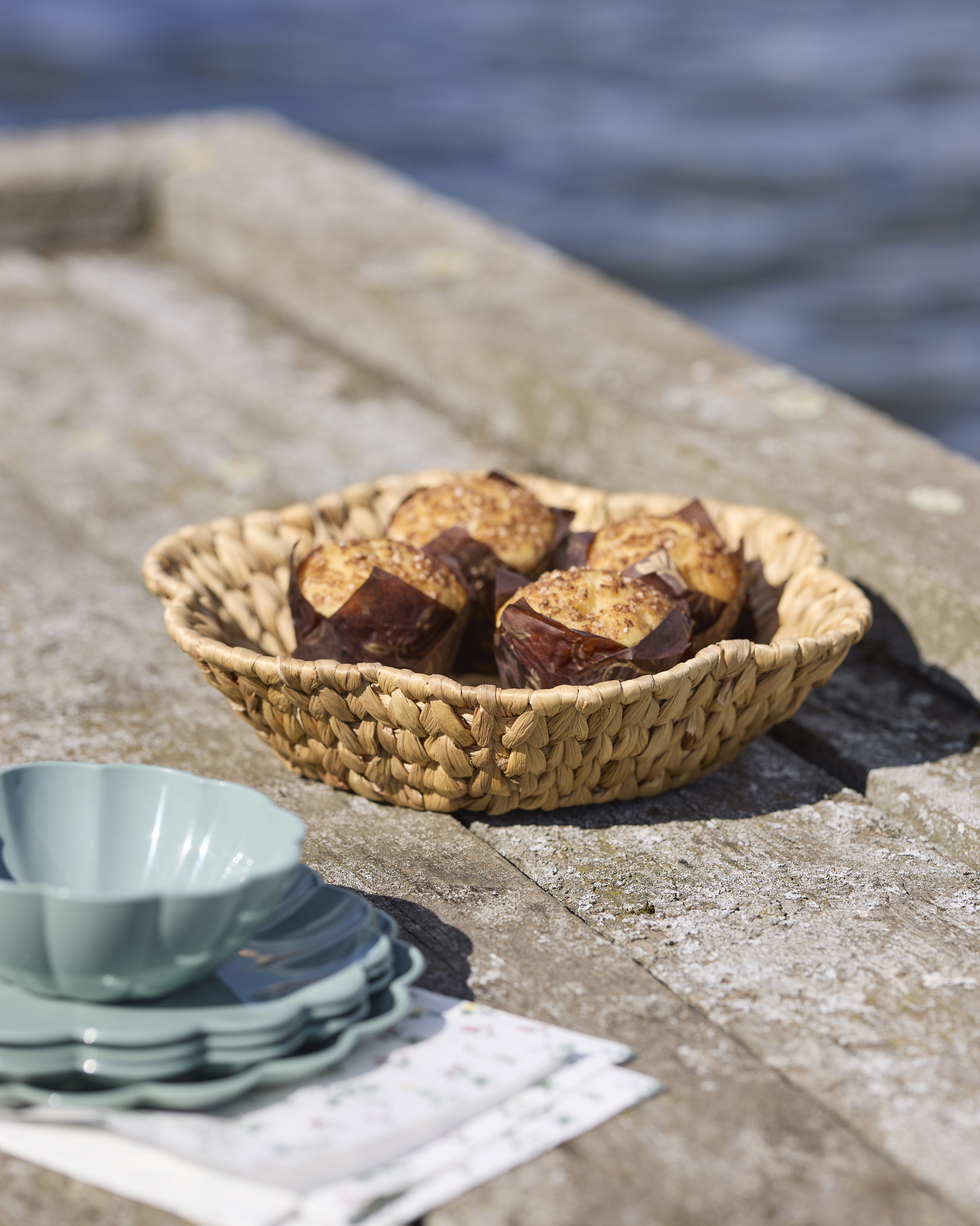 en korg med fika står på en brygga vid vattnet