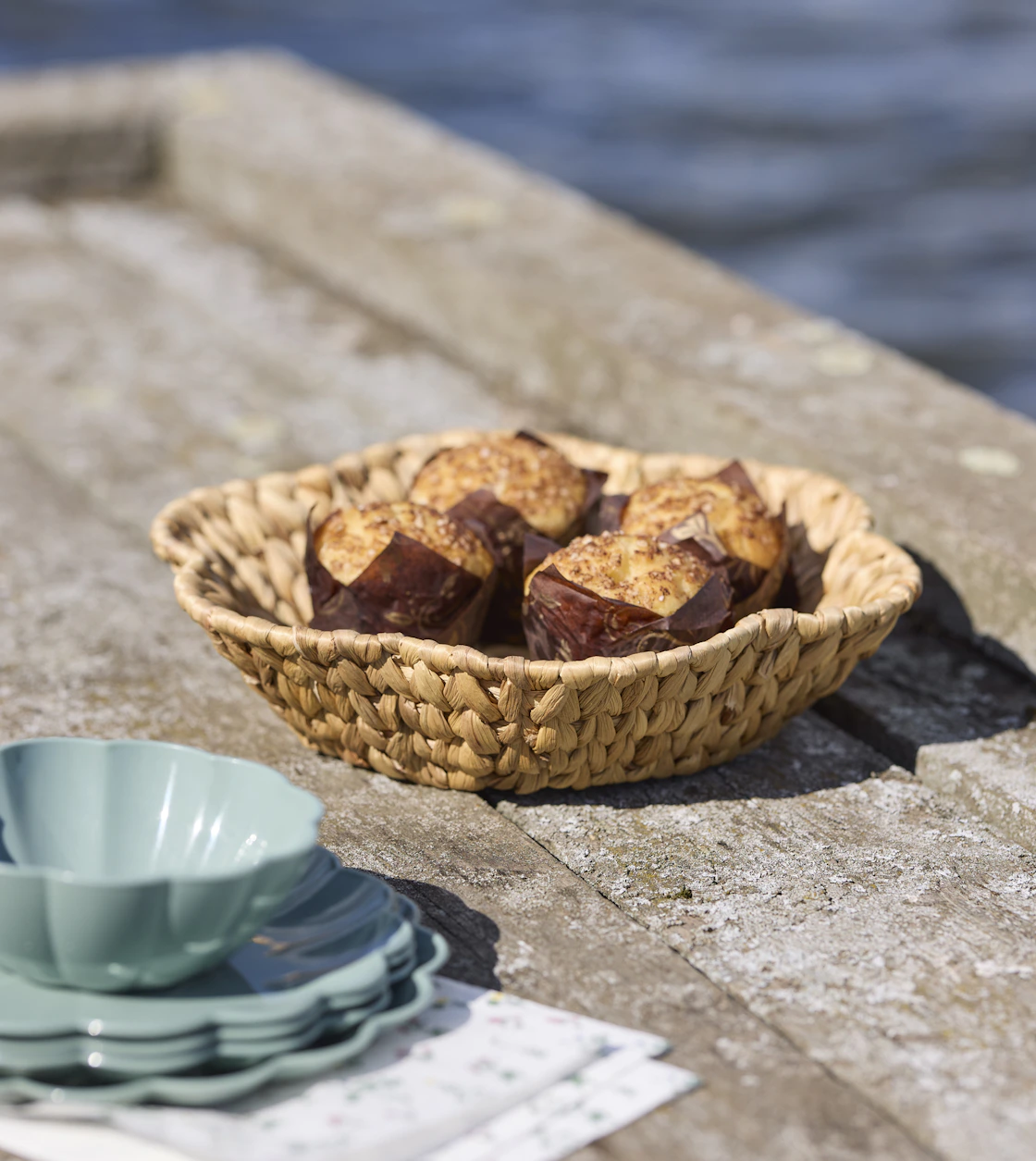 en korg med fika står på en brygga vid vattnet