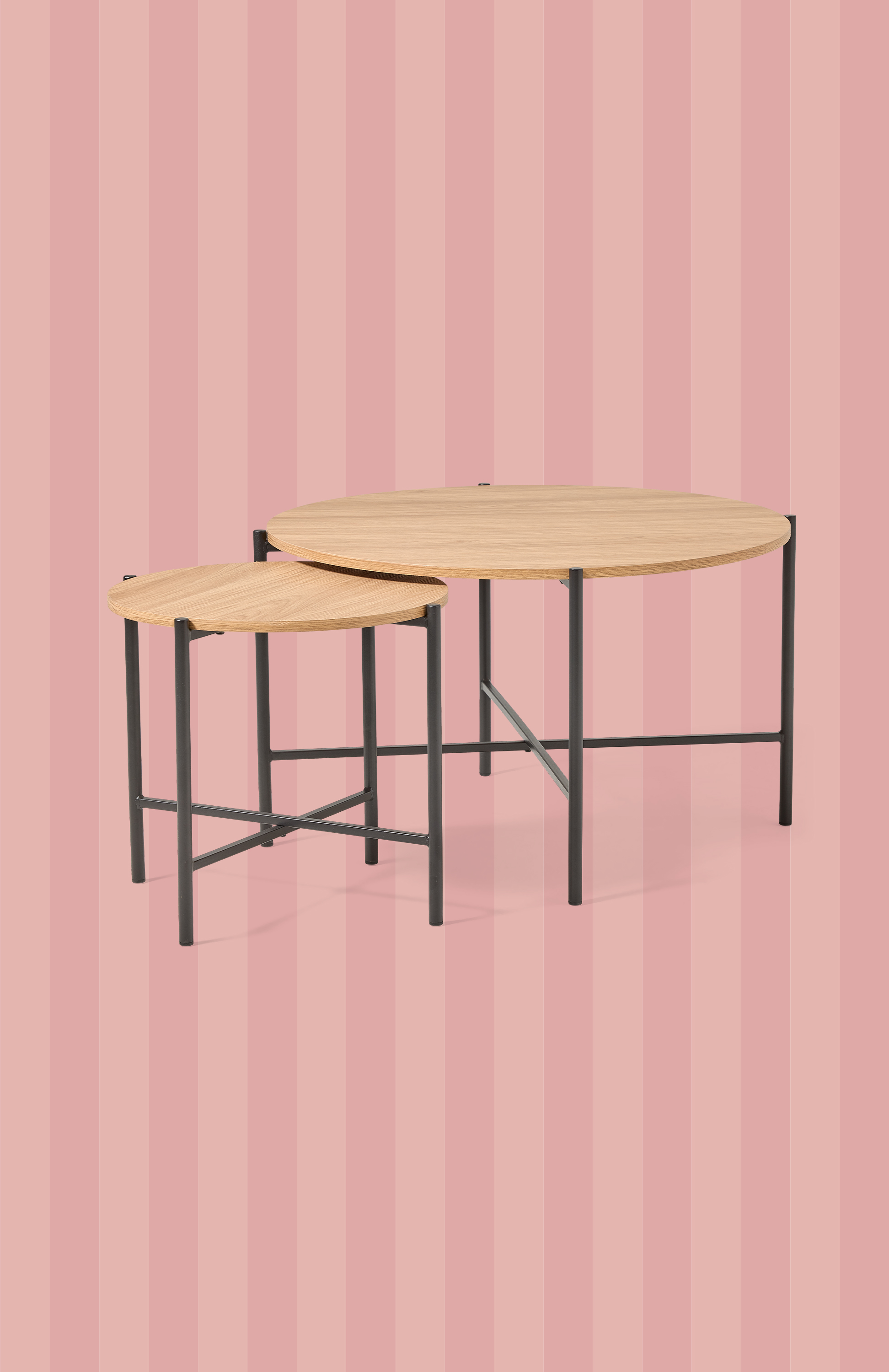 Emot en rosa och rödrandig bakgrund står två soffbord med ljus träskiva och svarta ben