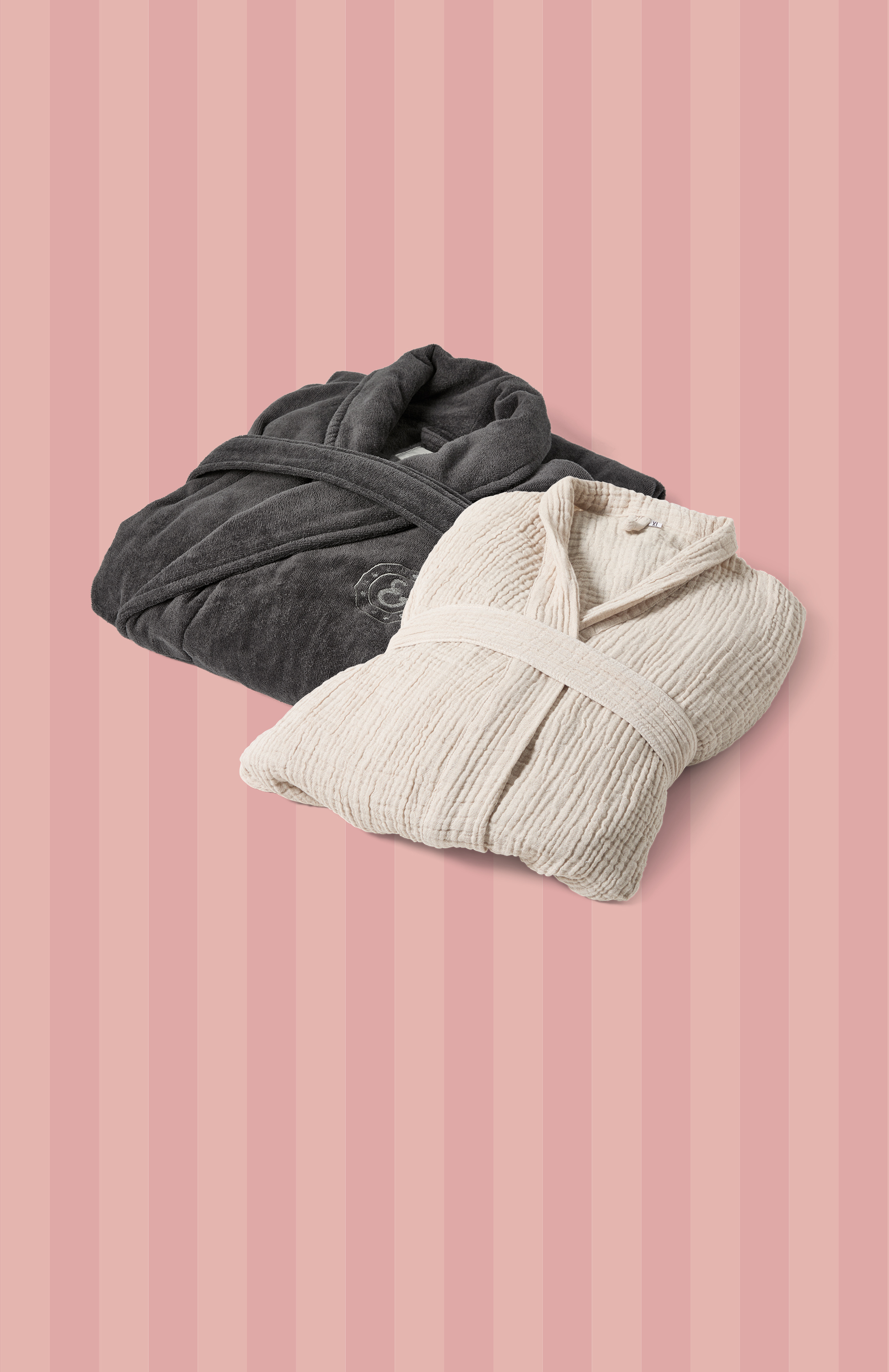 Emot en rosa och rödrandig bakgrund ligger en grå och en beige badrock