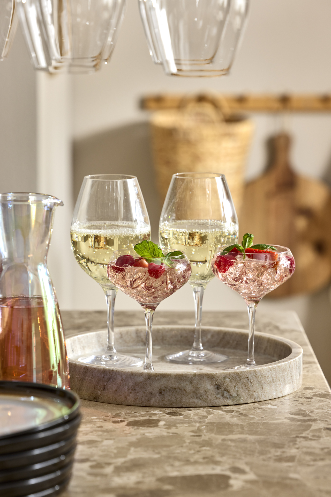 Två vinglas och två champagneglas står på en marmorbricka.