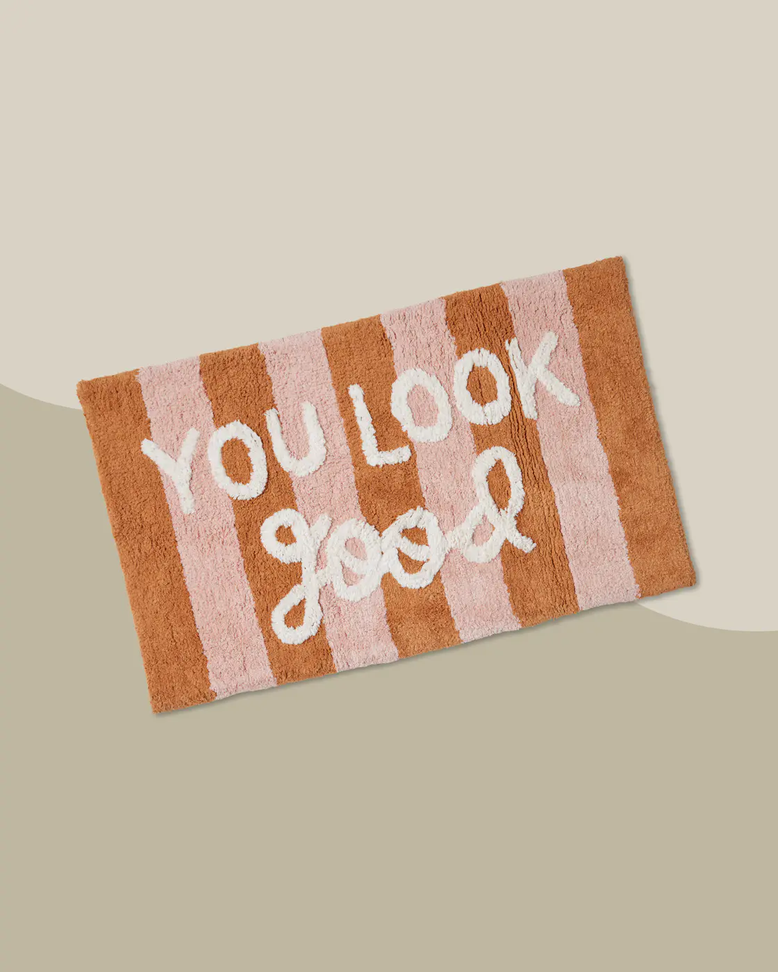 Bild på en randig badrumsmatta med texten "you look good"